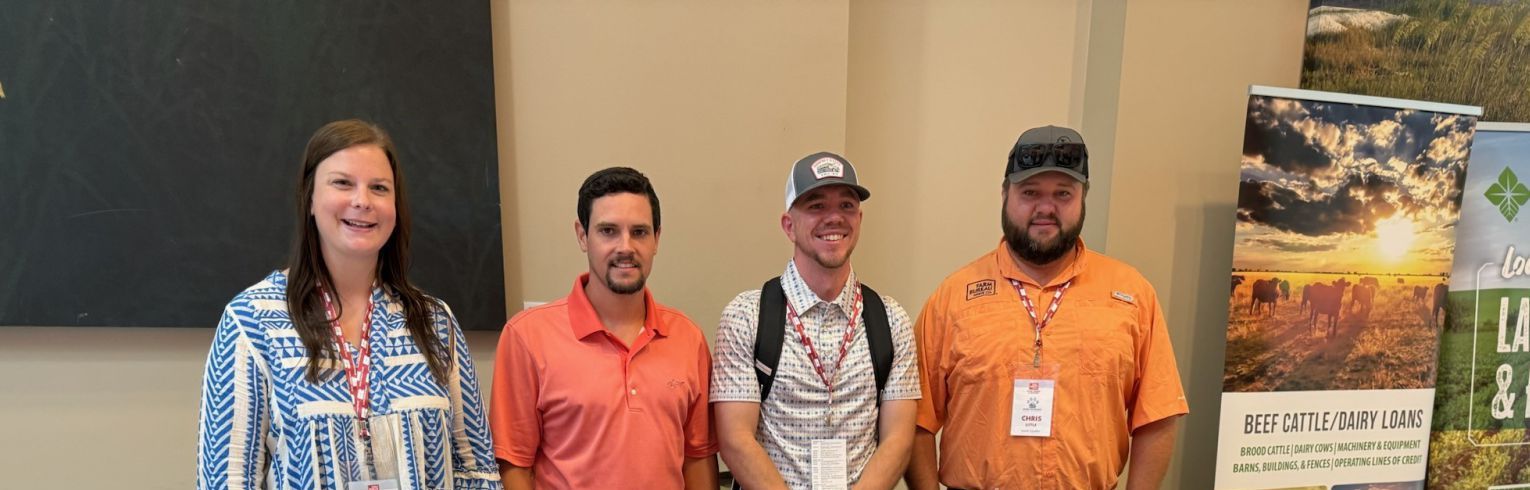 Four people standing at a table at an event
