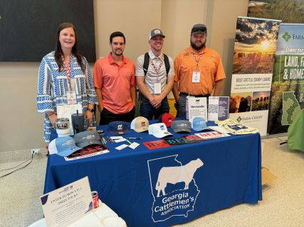 People standing behind a GCA table at an event